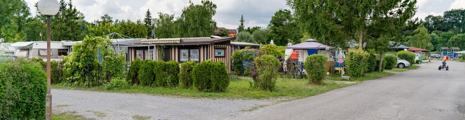 Reihe von Stellplätzen mit Hecken und Vordächern